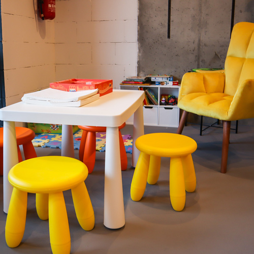 kącik do zabawy dla dzieci, kolorowe krzesełka, stolik, żółty fotel